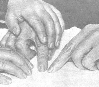 Los dedos de un alumno de Braille son guiados por el profesor